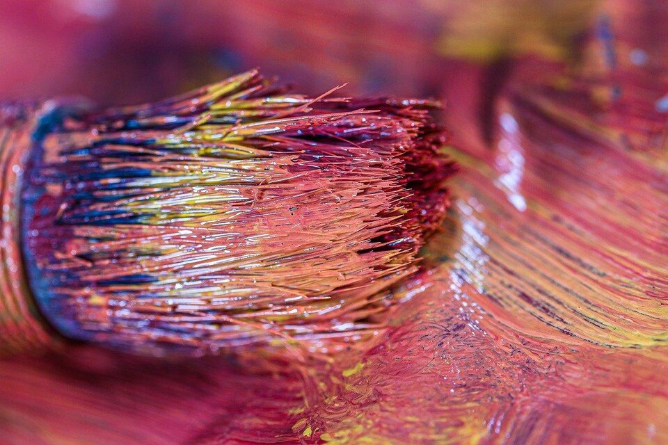 Ein Pinsel mit bunten Farbrändern liegt auf einer Farbfläche. Die Farben sind leuchtend und vermischen sich harmonisch. | © pixabay.com