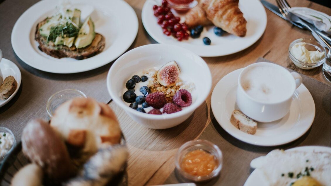 Ein reichhaltiges Frühstück mit verschiedenen Gerichten, darunter Brot, Croissants und Fruchtschalen. Dazu gibt es Kaffee und kleine Beilagen. | © G´sund und Natur Hotel Die Wasnerin