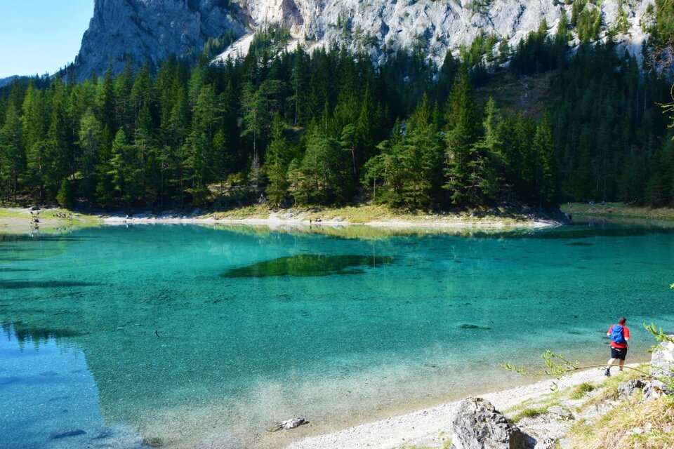 Ein ruhiger See umgeben von dichten Bäumen. Eine Bank lädt zum Verweilen und Genießen der Natur ein. | © Katarina Hager