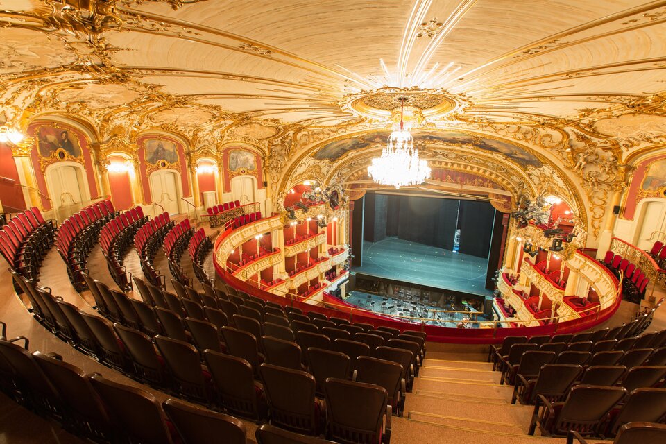 Ein prachtvolles Theater mit einem kunstvoll verzierten Innenraum. Die Reihen von roten Sitzplätzen sind um die Bühne angeordnet. | © Graz Tourismus - Harry Schiffer
