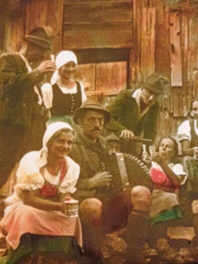 A historical, faded photograph featuring a typical Ausseer music group in traditional attire, preserving their customs and making music. | © Kammerhofmuseum