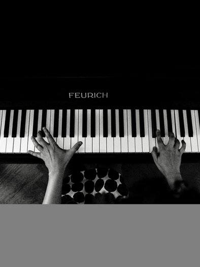 Eine Person spielt Klavier aus der Draufsicht. Die Hände bewegen sich über die Tasten eines schwarzen Klaviers. | © TVB Südsteiermark