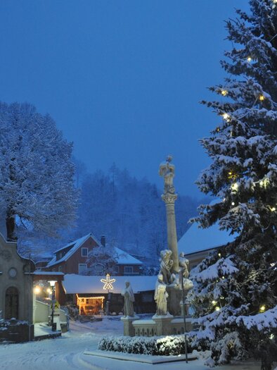 A quiet winter landscape with a festively decorated Christmas tree. The snow covers the surroundings and creates an enchanting atmosphere. | © TV Südsteiermark