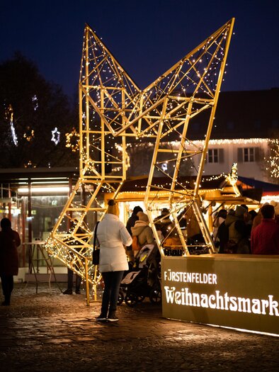 Eine dekorative Kugel aus Rattan mit warmem Licht. Im Hintergrund sind weiche Lichter, die eine gemütliche Atmosphäre schaffen. | © Stadtmarketing Fürstenfeld