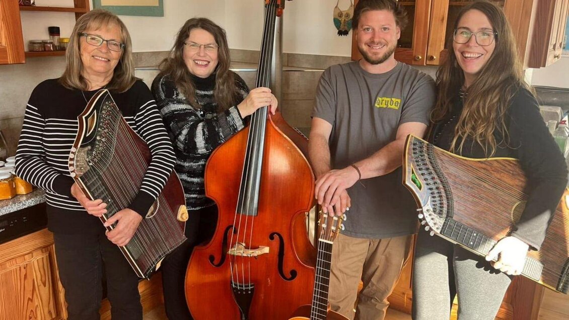 Gruppenbild der vier Musikanten der Gruppe Saitenspiel vom Simalhof, drei Frauen und ein Mann, mit ihren Instrumenten in einer gemütlichen Küche. | © Gabriele Marchner Trieb
