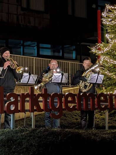 Flammen lodern von mehreren Kerzenstümpfen in der Dunkelheit. Die glühenden Flammen erzeugen eine warme, stimmungsvolle Atmosphäre. | © Marktgemeinde St. Michael