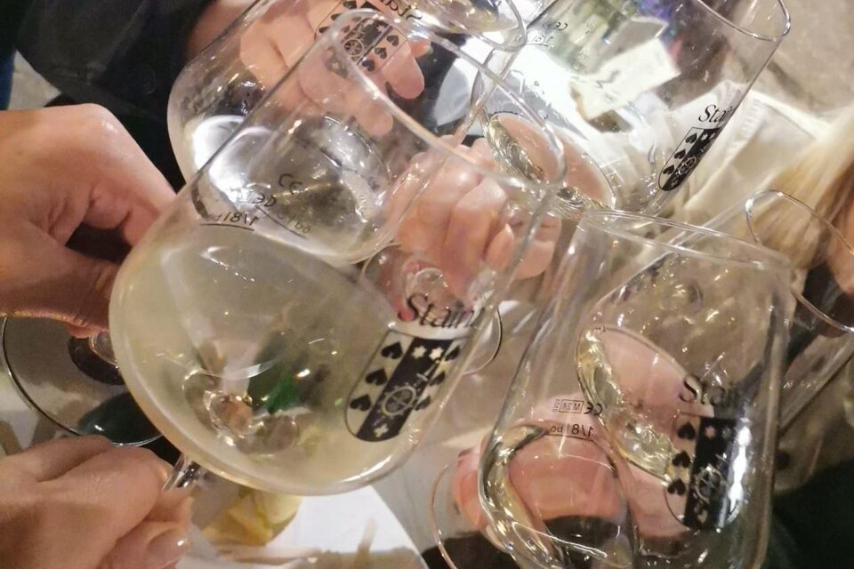 Eine Gruppe von Personen hebt Gläser mit Sekt an, um anzustoßen. Die Gläser sind beschriftet und es herrscht eine festliche Stimmung. | © TV Südsteiermark - Irene Löschnig