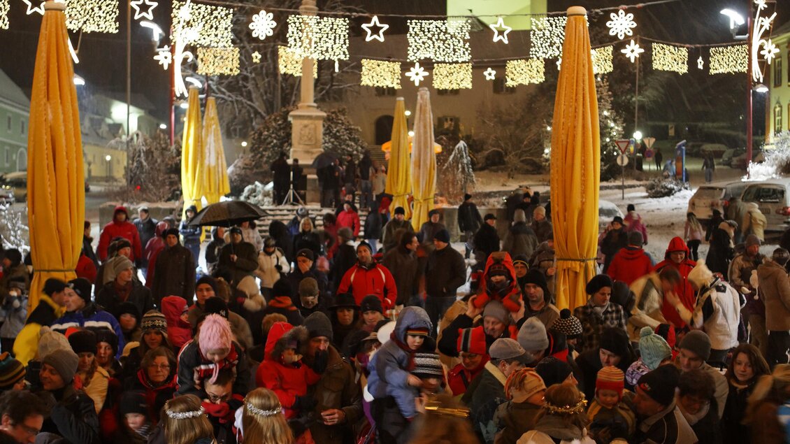 Ein lebhafter Weihnachtsmarkt mit vielen Menschen, die sich um Stände und Lichter versammeln. Über dem Platz hängen festliche Sterne und Lichterdekorationen. | © Tourismusverband Oststeiermark