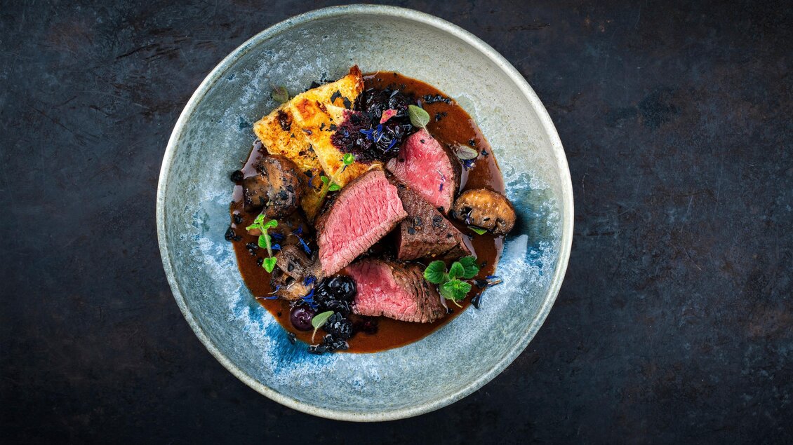 Ein ansprechend angerichteter Teller mit zartem Fleisch, Beilagen und einer dunklen Sauce. Die Farben und Texturen sorgen für einen appetitlichen Eindruck. | © Adobe Stock