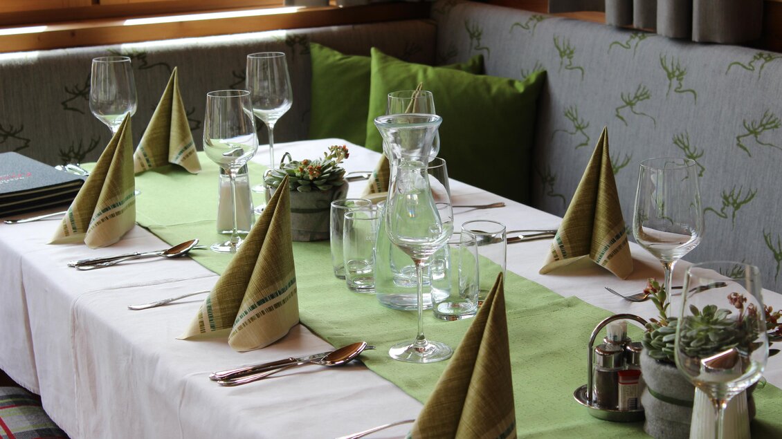 Ein schön gedeckter Tisch mit eleganten Gläsern und dekorativen Servietten. Die hellen Farben und die üppigen Pflanzen schaffen eine einladende Atmosphäre. | © Tourismusverband Oststeiermark