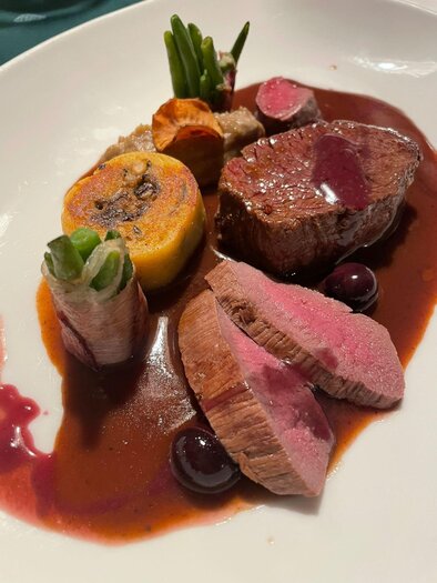 An artistically arranged plate with tender meat, fresh vegetables, and a red sauce. The dishes are attractively presented and invite to be enjoyed. | © Winterleitenhütte