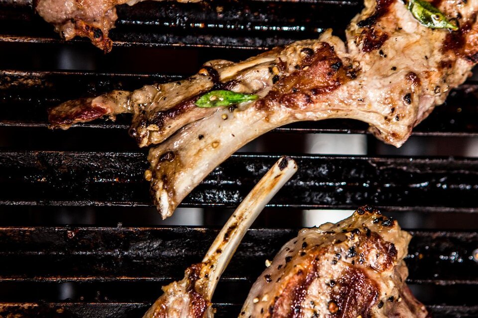 Gegrillte Lammkoteletts auf einem Grillrost. Die Koteletts sind knusprig und gut gewürzt.
