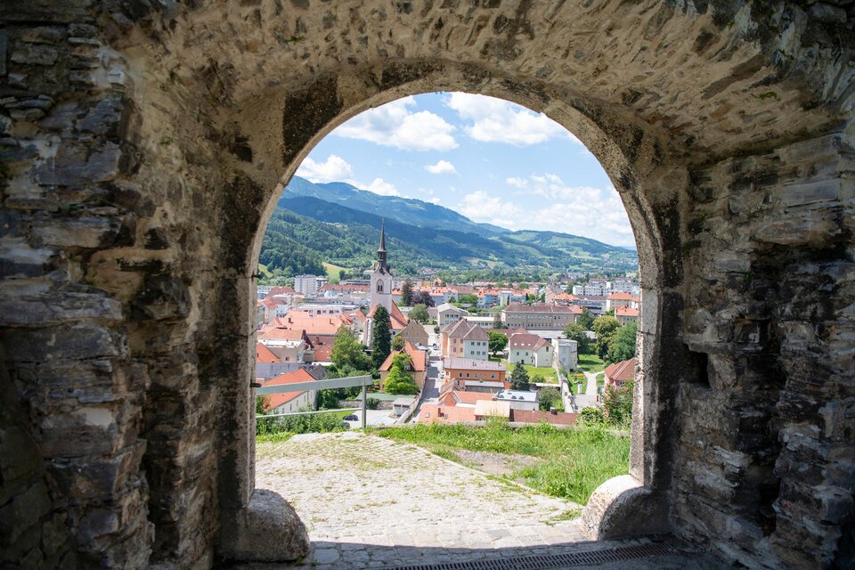 Das Bild zeigt den Blick auf die Stadt Bruck an der Mur mit vielen Dächern und der Pfarrkirche, vom Schlossberg hinunter