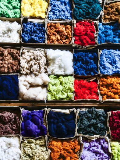Ein bunter Tisch mit verschiedenen Wollen in kleinen Kisten. Die Farben reichen von Blau und Rot bis zu Grün und Beige. | © pixapay