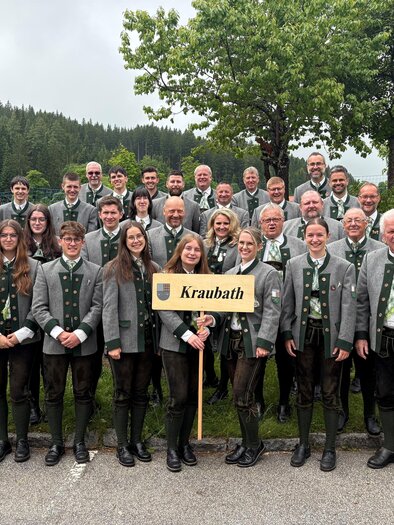Eine Gruppe von Menschen in traditioneller Kleidung steht zusammen in der Natur. Sie halten ein Schild mit der Aufschrift "Kraubath". | © Marktgemeinde Kraubath