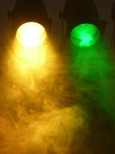 Focused light in blue, green, yellow, and red shines through a slightly misty background. The lights create a festive atmosphere. | © Pixabay