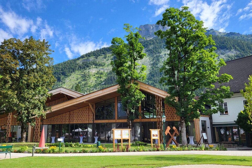 <p><p>Der klimafitte Kurpark mit dem neu erbauten Veranstaltungssaal in Altaussee. Dahinter der Loser mit blauem Himmel.</p></p> | © Petra Kirchschlager/ Tourismusverband Ausseerland Salzkammergut