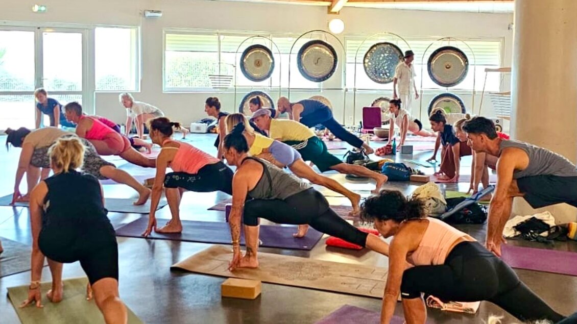 Teilnehmer beim Gruppenyoga auf Matten während eines Yogaweekends in einem hellen Studio in Graz. | © Yogaweekend