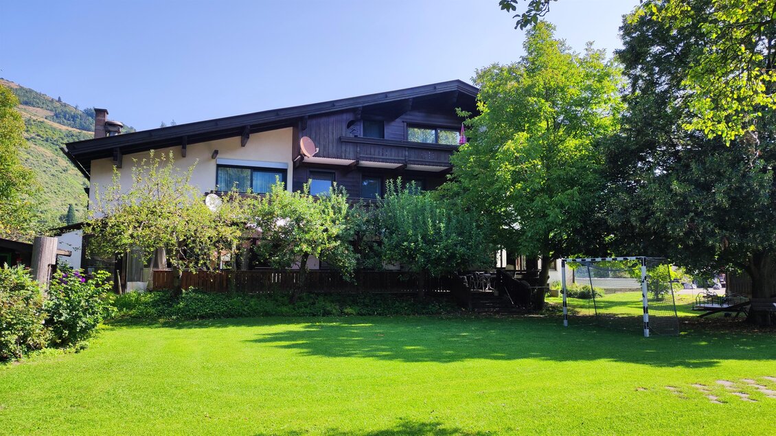 Ein großes Haus mit einem gepflegten Garten und vielen Bäumen. Der Rasen ist grün und das Wetter ist schön. | © Landhaus Camping Pichler