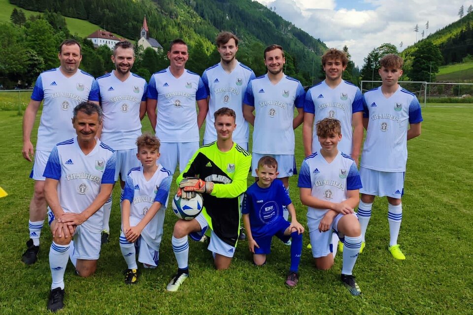 Eine Fußballmannschaft posiert auf dem Spielfeld. Die Spieler tragen blaue und weiße Trikots und lächeln in die Kamera. | © USV Bretstein