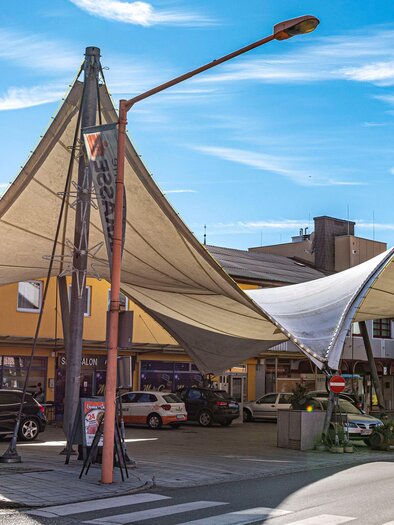 A modern marketplace with shade-providing fabric roofs. The surroundings are bright and welcoming, ideal for a shopping stroll. | © Platzlmarkt