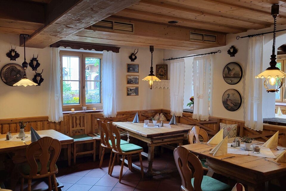 Ein gemütliches Restaurant mit Holzinterieur und rustikalen Tischen. Die Wände sind mit dekorativen Platten und Bildern geschmückt. | © Petra Kirchschlager