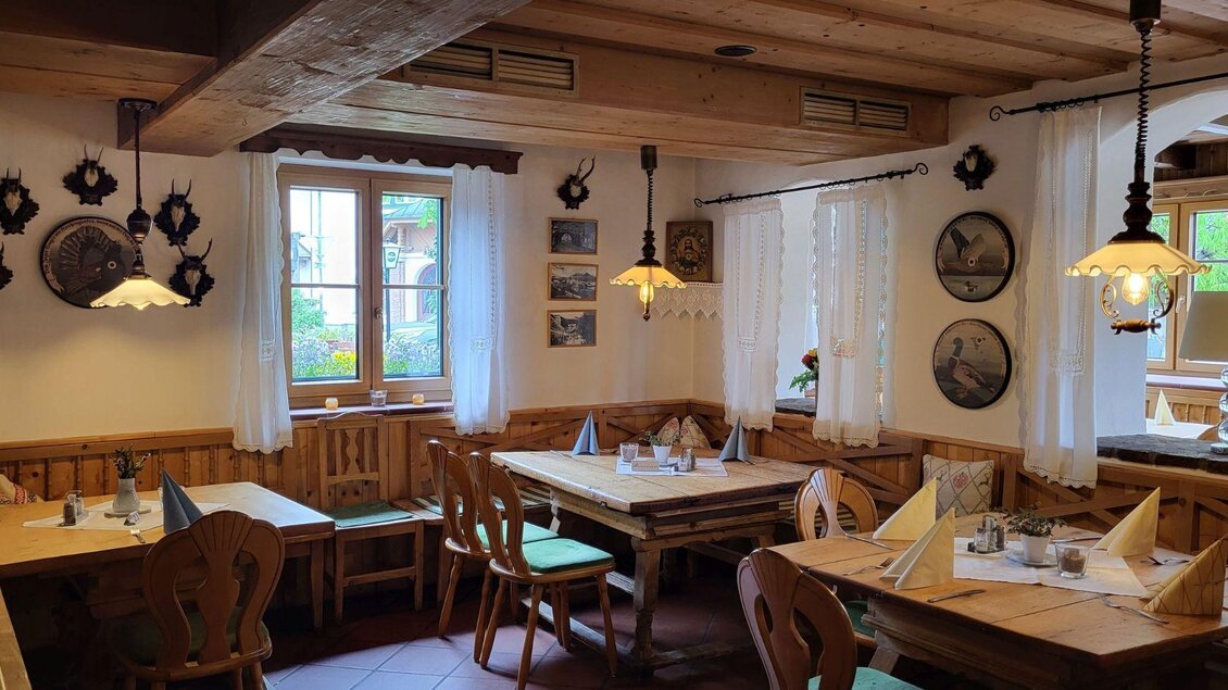 Ein gemütliches Restaurant mit Holzinterieur und rustikalen Tischen. Die Wände sind mit dekorativen Platten und Bildern geschmückt. | © Petra Kirchschlager