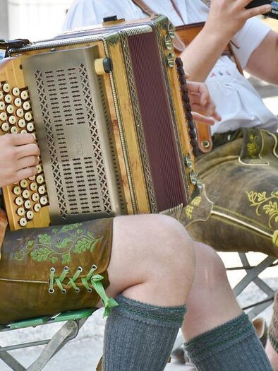 Zwei Musiker in traditioneller bayerischer Tracht spielen ein Akkordeon und ein Blasinstrument. Die Kleidung ist farbenfroh und reicht bis zu den Oberschenkeln. | © Pixabay