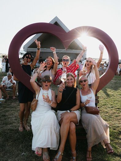 A celebration with cheerful people raising their glasses. The atmosphere is lively and festive. | © south.