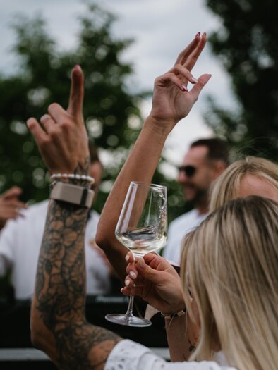 A celebration with cheerful people raising their glasses. The atmosphere is lively and festive. | © south.