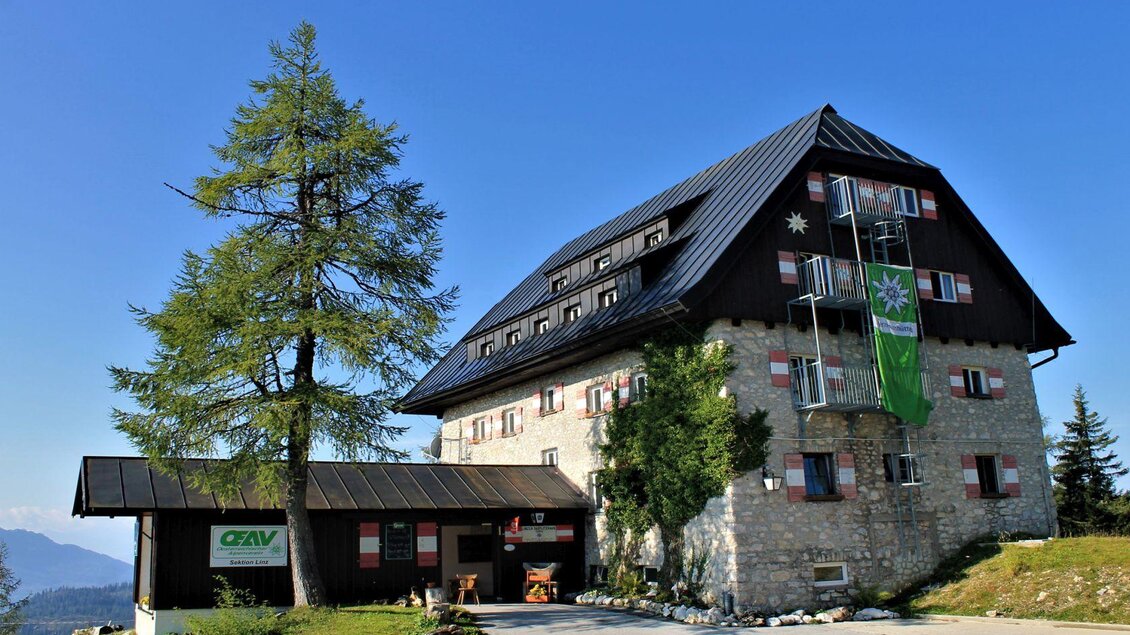 <p>Das Linzerhaus umgeben von Bäumen und einer schönen Berglandschaft.</p> | © Erika Marton