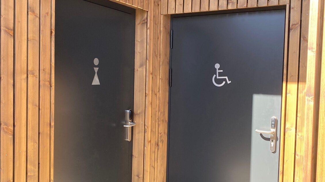 Zwei Türen zu Toiletten, eine für Damen und eine behindertengerechte. Der Raum ist mit Holz verkleidet und gut beleuchtet. | © Manuela Schweinzer-Riegler
