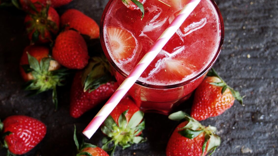 <p>Ein erfrischendes Getränk mit Erdbeeren und Eiswürfeln. Umgeben von frischen Erdbeeren auf einer dunklen Oberfläche. Rogner Bad Blumau</p> | © Rogner Bad Blumau