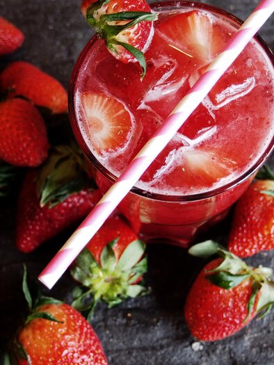 <p>Ein erfrischendes Getränk mit Erdbeeren und Eiswürfeln. Umgeben von frischen Erdbeeren auf einer dunklen Oberfläche. Rogner Bad Blumau</p> | © Rogner Bad Blumau