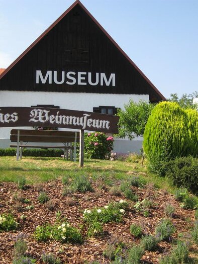 A museum named "Styrian Wine Museum" in a rural setting. The building has a traditional design and is surrounded by green plants. | © TV Südsteiermark