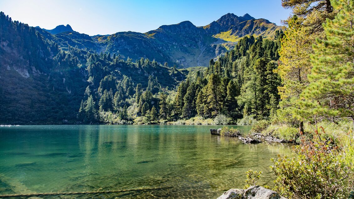 Ein klarer See umgeben von grünen Bäumen und majestätischen Bergen. Der Himmel ist blau und strahlend. | © Erlebnisregion Murtal