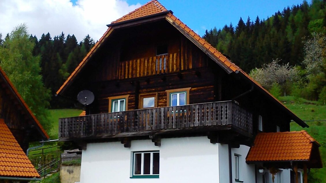 Ein charmantes altes Haus im Allgäu-Stil mit einem schrägen Dach und einem Balkon. Umgeben von grünen Wäldern und einer schönen Landschaft. | © A. Steininger