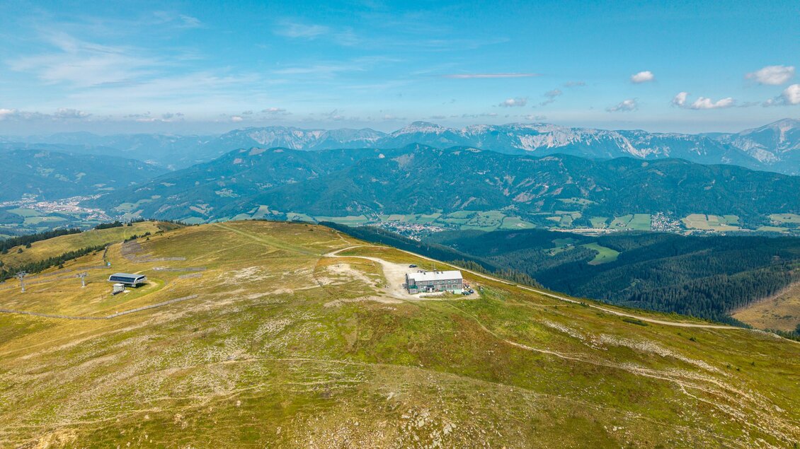 zu sehen ist das Alois Günther Haus auf der Pretul und eine Luftaufnahme der Fischbacher Alpen. | © Lucas Vollmann