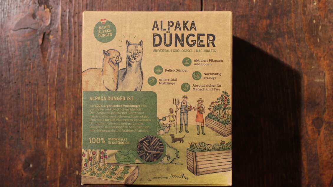Eine Packung mit "Alpaka Dünger" aus umweltfreundlichem Material. Auf der Verpackung sind Illustrationen von Alpakas und Gartenarbeit zu sehen. | © Ganster