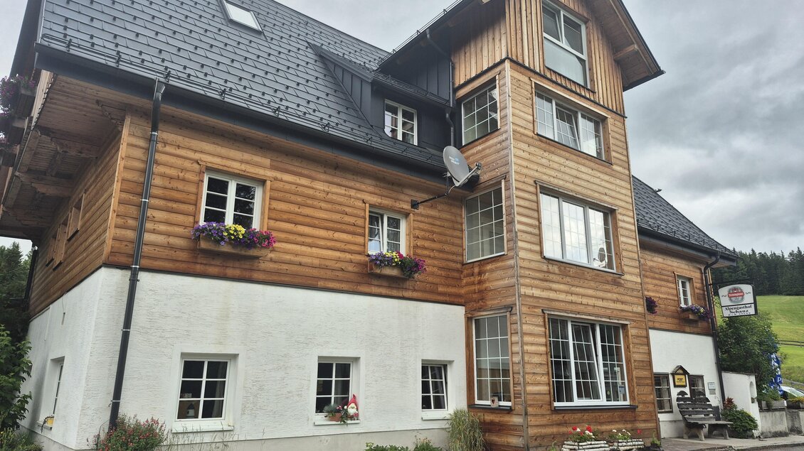 Ein modernes Mehrfamilienhaus mit Holz- und Putzfassade. Es ist von einer grünen Umgebung umgeben und hat große Fenster. | © TV Hochsteiermark