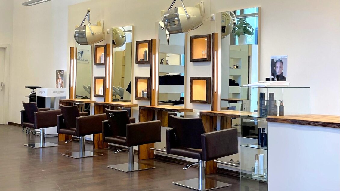 Ein moderner Friseursalon mit stilvollen Stühlen und großen Spiegeln. Der Raum ist hell und ordentlich eingerichtet. | © Alpenhaar Bad Aussee