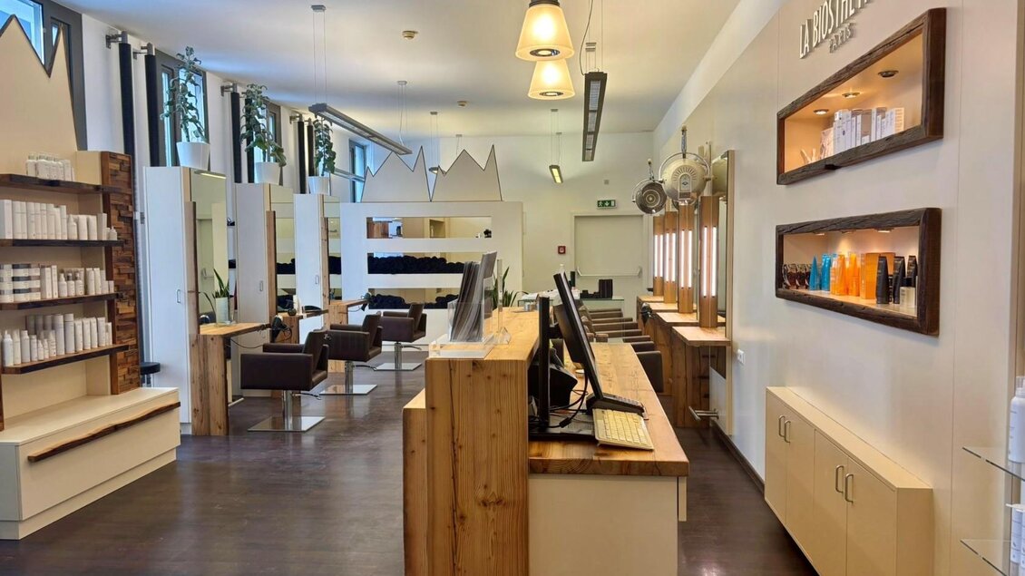 Ein modern eingerichteter Friseursalon mit hellen Wänden und Holzelementen. Die Innenräume sind sauber und gut organisiert, mit gemütlichen Sitzgelegenheiten. | © Alpenhaar Bad Aussee