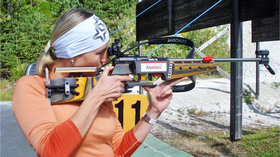 Eine Frau schießt mit einem Luftgewehr auf einer Schießbahn. Sie trägt einen Sportanzug und konzentriert sich auf ihr Ziel. | © Alpincenter Dachstein
