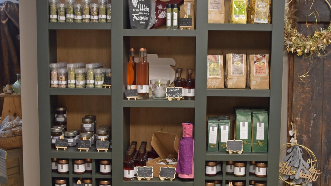 Ein schöner Holzschrank mit verschiedenen Gläsern, Flaschen und verpackten Lebensmitteln. Oben auf dem Schrank liegen einige Geweihstücke. | © Familie Stiendl