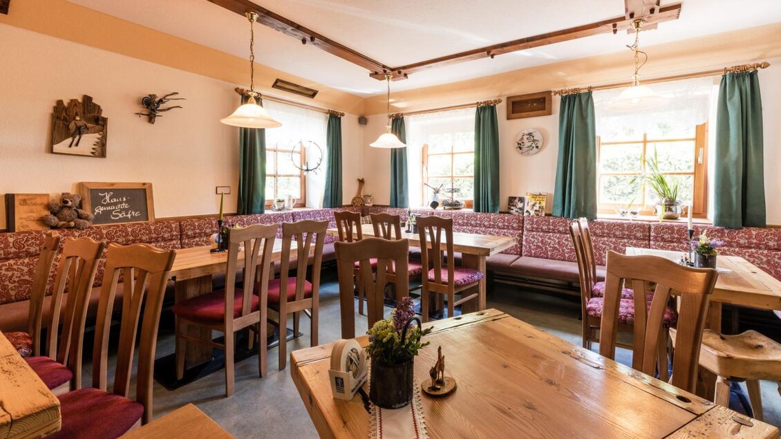 Gemütliche Gaststube mit Holztischen, Eckbank und traditioneller Einrichtung. | © Gasthaus Angermaier