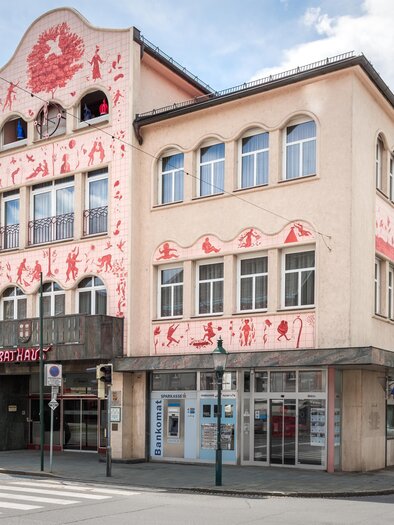 Town hall Voitsberg with the facade designed by Arik Brauer and red figurative paintings | © TV Region Graz - Die Abbilderei