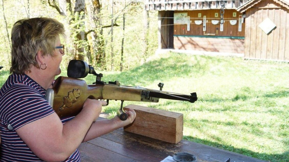 Eine Person schießt mit einem Gewehr auf einem Schießstand. Im Hintergrund sind Zielscheiben und grüne Wiese zu sehen. | © Ausseer Stahelschützen