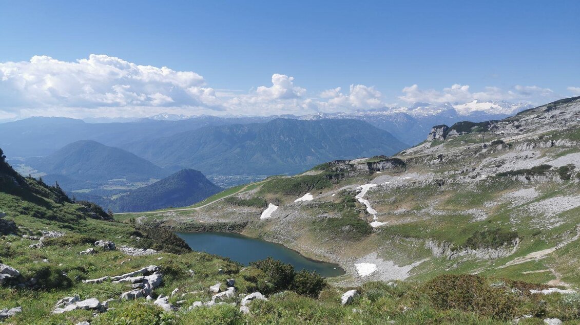 Eine malerische Berglandschaft mit einem klaren See und majestätischen Bergen im Hintergrund. Der Himmel ist blau und mit einigen Wolken bedeckt. | © TVB Ausseerland-Salzkammergut/Theresa Schwaige