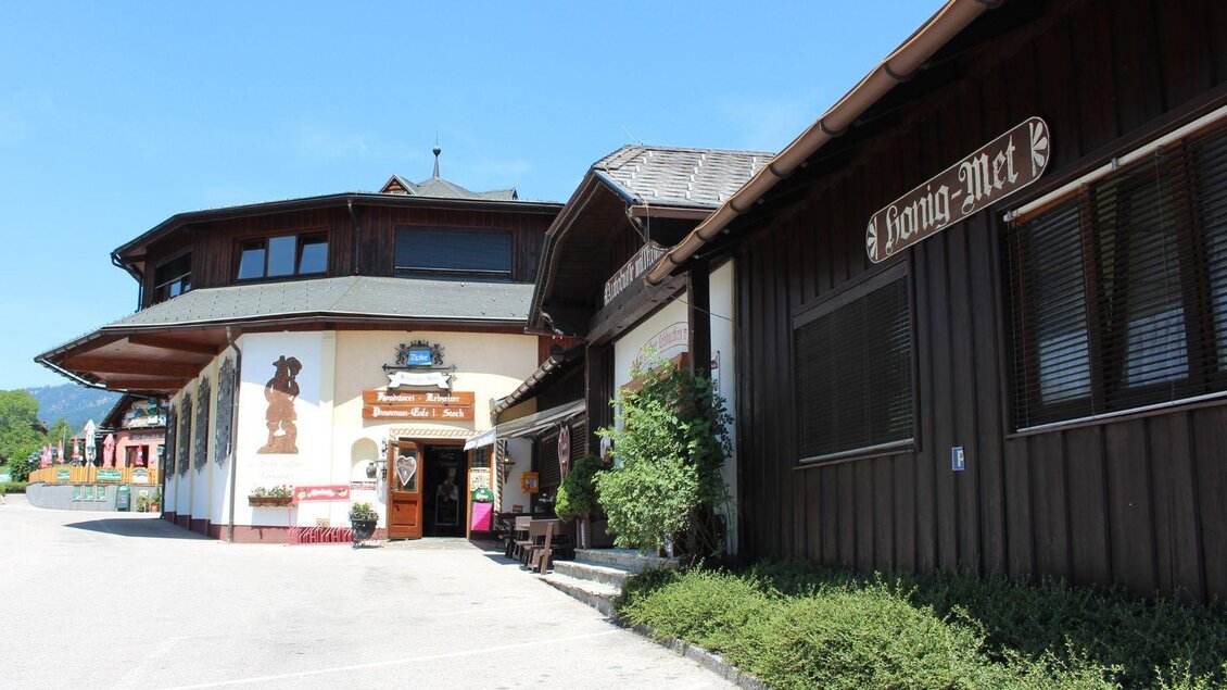 Ein traditionelles Holzgebäude mit dem Schild „König Max“. Es befindet sich in einer sonnigen Umgebung mit einem klaren blauen Himmel. | © Ausseer Lebkuchen
