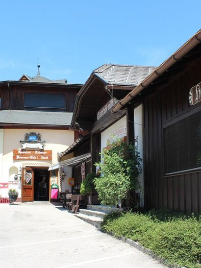 Ein traditionelles Gebäude mit Holzfassade und einem einladenden Eingang. Umgeben von grüner Vegetation und klarem blauen Himmel. | © TVB Ausseerland Salzkammergut/Viola Lechner